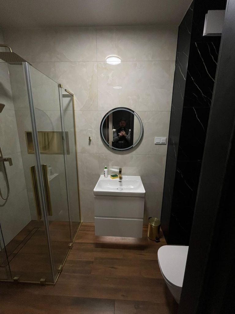 Łazienka z kabiną prysznicową i okrągłym lustrem