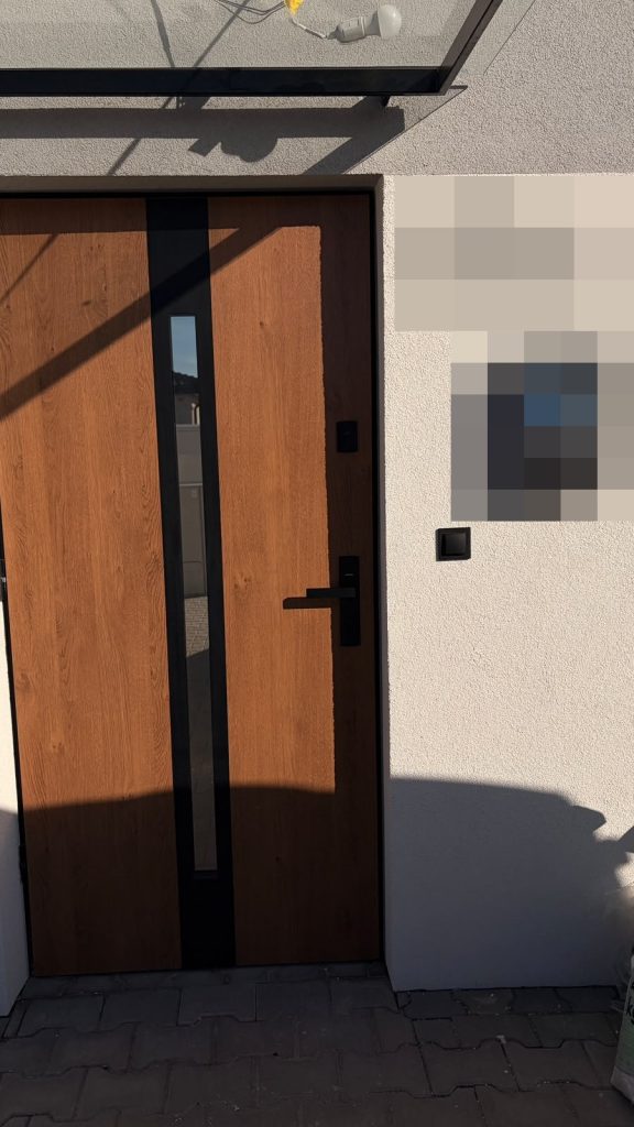 Drzwi zewnętrzne w kolorze drewna z pionowym przeszkleniem