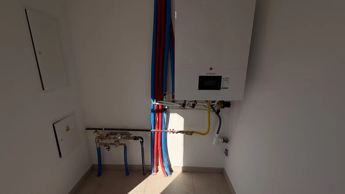 Instalacja hydrauliczna w kotłowni: kocioł, rury w otulinach i wodomierze